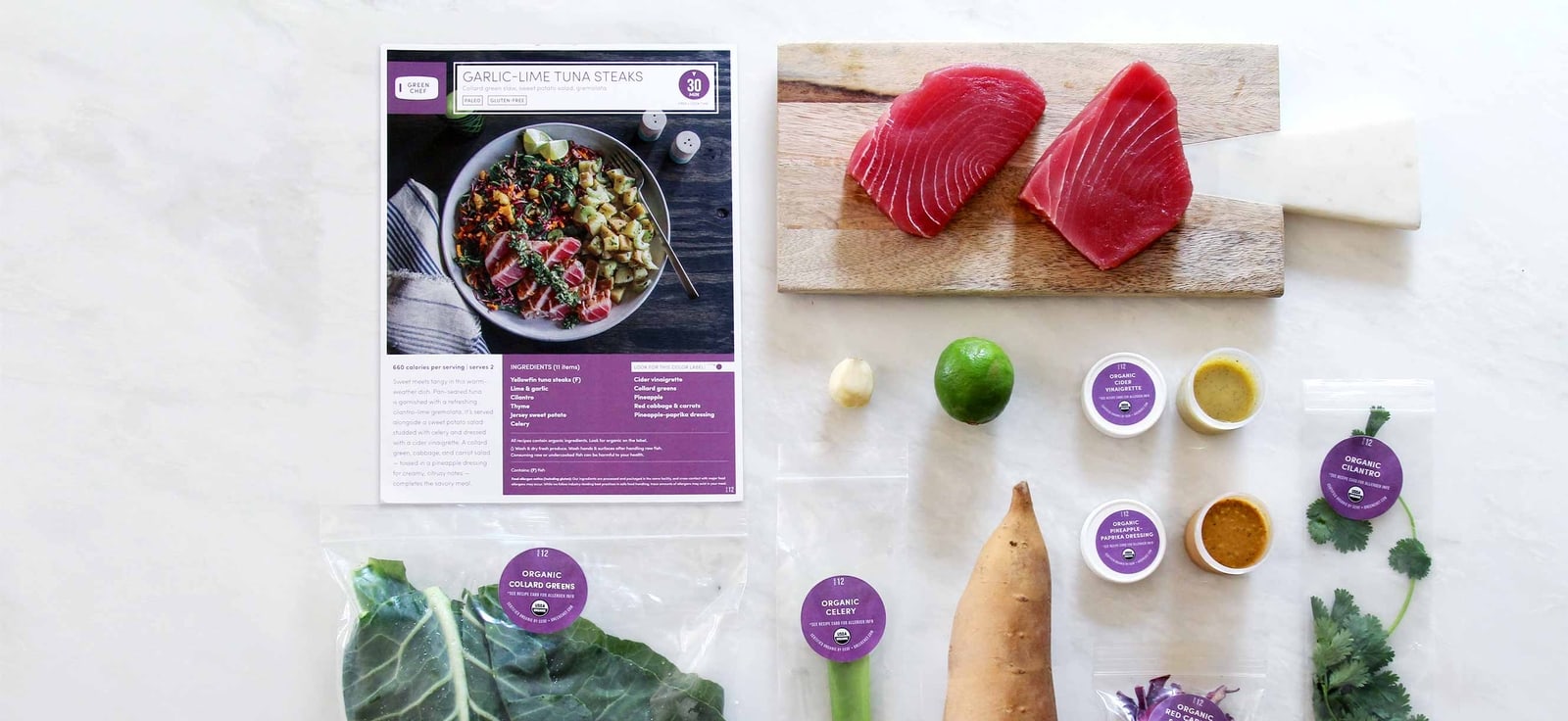 A Green Chef meal kit: recipe card, fresh ingredients, and portioned sauces laid out